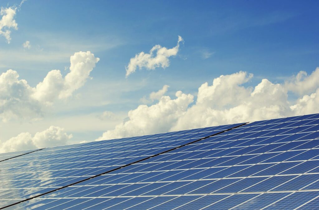 pexels photo 356036 Sleek modern solar panels under a vibrant blue sky with clouds, symbolizing clean energy.
